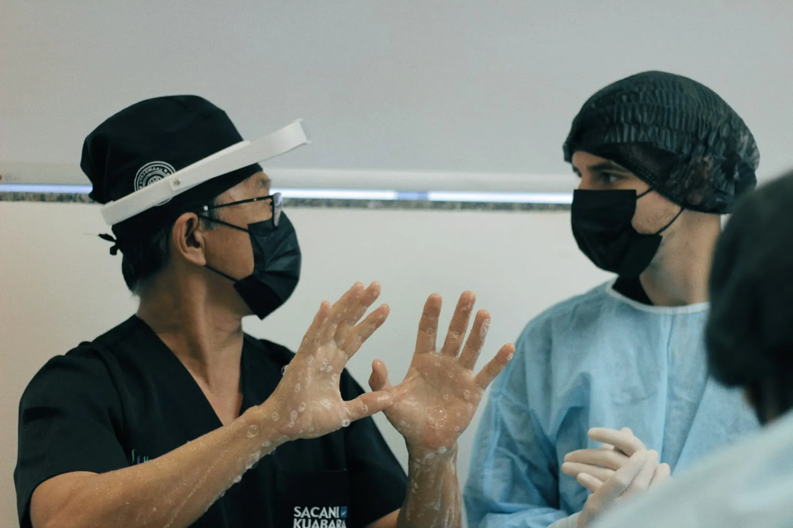 Dr. Kuabara orientando aluno na degermação das mãos