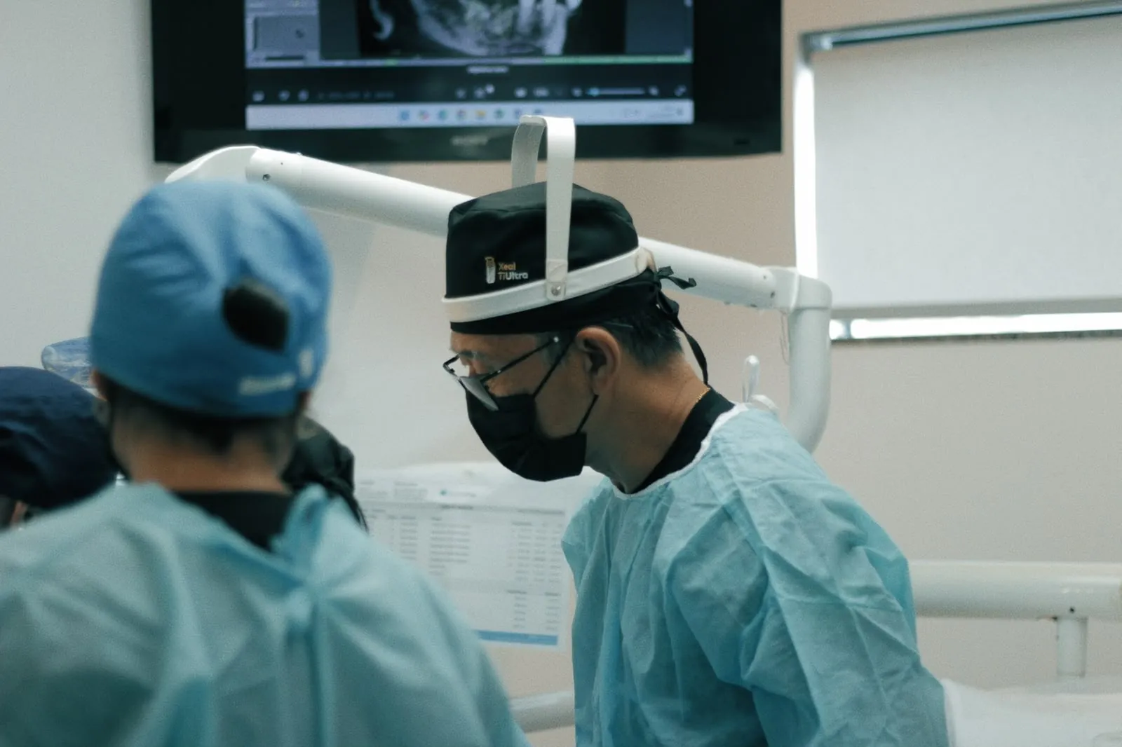 Dr. Kuabara analisando tomografia durante cirurgia com os alunos