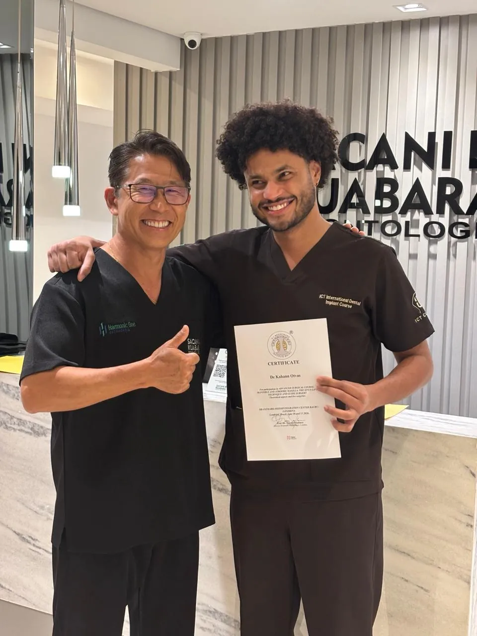 Dr. Kuabara parabenizando aluno com o certificado